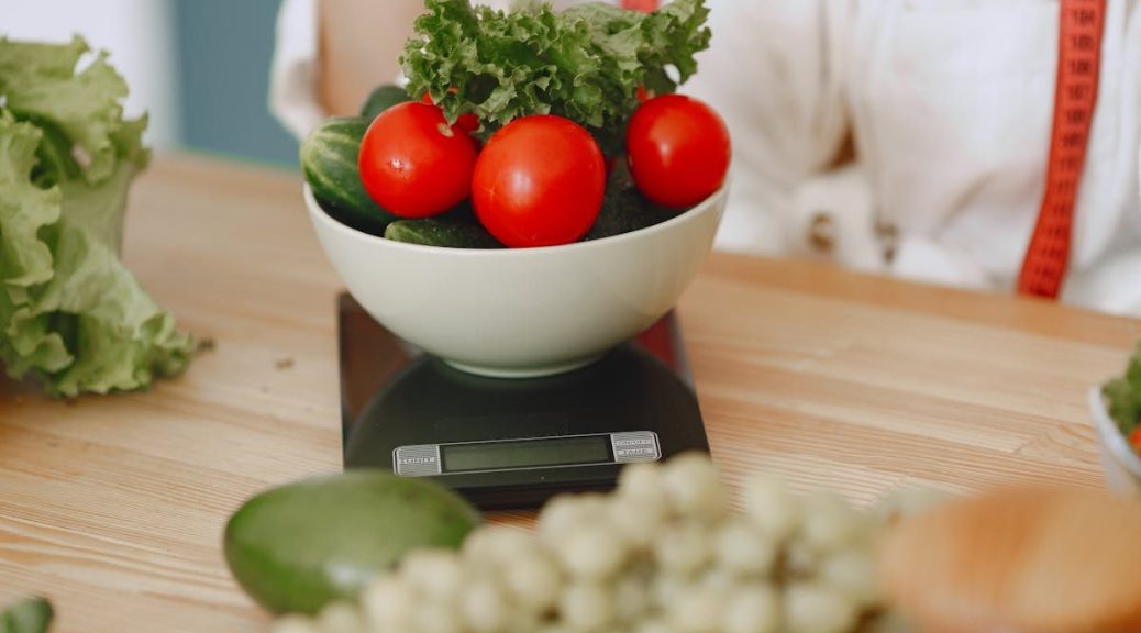Colorful fresh vegetables including tomatoes and cucumbers on a kitchen scale for healthy eating.